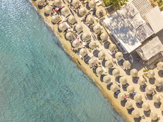 Aerial view of beach with straw parasols on shore of Achaia, Greece. - AAEF00496
