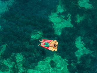 Luftaufnahme eines Mannes, der in einem Schlauchboot am Strand von Katomeri, Griechenland, schwimmt. - AAEF00526