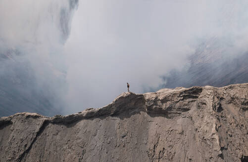 Aerial view of a man standing of the edge of mount Bromo in east of Java island, Indonesia. - AAEF00645