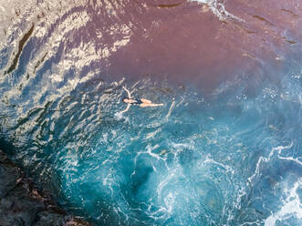 Luftaufnahme einer attraktiven Frau, die auf transparentem Wasser schwimmt, Hawaii, U.S.A. - AAEF00653