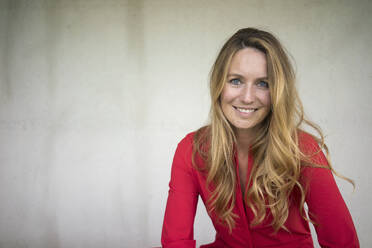 Portrait of smiling woman wearing red jumpsuit - MOEF02457