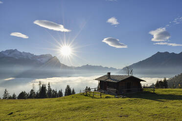 Blockhaus am Wank vor Zugspitze und Wolkenlandschaft bei Sonnenuntergang, Bayern, Deutschland - RUEF02302