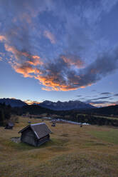 Blockhaus auf einer Wiese vor dem Geroldsee und dem Karwendelgebirge in Bayern, Deutschland - RUEF02307