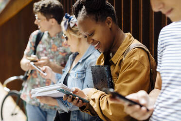 Studenten, die sich in einem Hinterhof treffen, reden und ihre Smartphones entsorgen - SODF00064