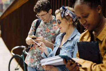 Studenten, die sich in einem Hinterhof treffen, reden und ihre Smartphones entsorgen - SODF00065