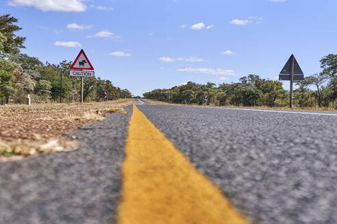 Höhe des Warzenschwein-Kreuzungszeichens an der Straße gegen den Himmel, Mpumalanga, Südafrika - VEGF00448