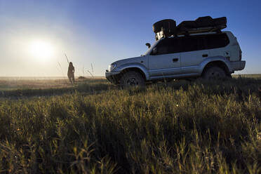 Frau neben Geländewagen in den Makgadikgadi Pans, Botswana - VEGF00450