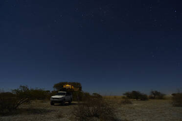 Tent on off-road vehicle on field against sky at night, Makgadikgadi Pans, Botswana - VEGF00453