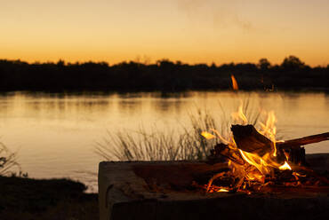 Bonfire at riverbank during sunset at Caprivi Strip, Namibia - VEGF00478