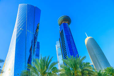 Niedriger Blickwinkel auf den Al Fardan Towers-Komplex und den Doha Tower, ikonische verglaste Hochhäuser in der West Bay, Wolkenkratzer des Finanzdistrikts im Licht des Sonnenuntergangs im Jahr 2019, Doha, Katar, Naher Osten - RHPLF00182