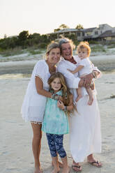 Caucasian family smiling on beach - BLEF13760