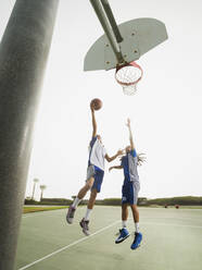 Teenager spielen Basketball auf dem Platz - BLEF13792