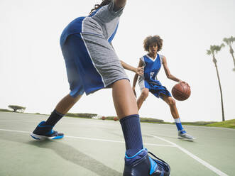 Teenage boys playing basketball on court - BLEF13793