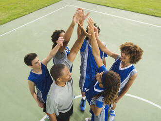 Basketball team high fiving on court - BLEF13794