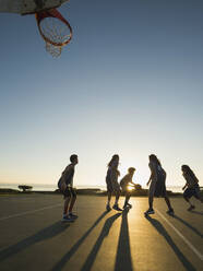 Back lit basketball teams playing on court - BLEF13807