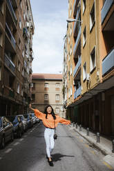 Asian woman walking on a road in Granada, Spain - LJF00618