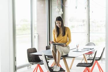 Young businesswoman using tablet in office - UUF18471