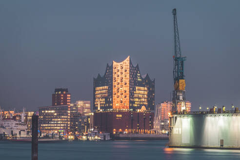 Beleuchtete Elbphilharmonie an der Elbe gegen den Himmel in Hamburg in der Abenddämmerung, Deutschland - KEBF01278