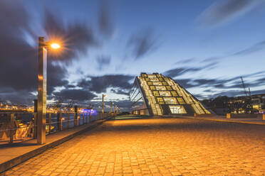 Diminishing perspective of footpath by Dockland building against sky at dusk, Hamburg, Germany - KEBF01286