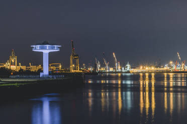 Illuminated lighthouse Zero by Elbe river against sky at night, Hamburg, Germany - KEBF01313