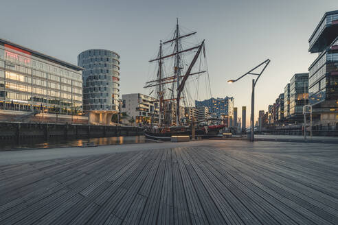 Schiff im Hafen gegen den Himmel in der HafenCity bei Sonnenuntergang, Hamburg, Deutschland - KEBF01314