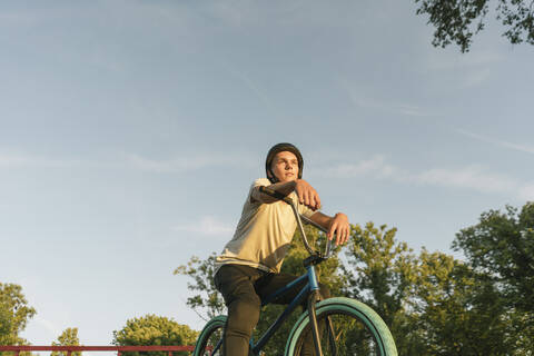 Junger Mann mit BMX-Rad im Skatepark, der eine Pause macht, lizenzfreies Stockfoto