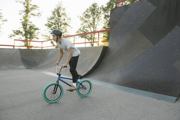 Young man riding BMX bike at skatepark - AHSF00743