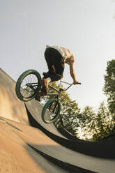 Young man riding BMX bike at skatepark - AHSF00758