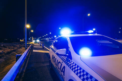 Police car patrol on road of Madrid during night - OCMF00569