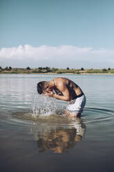 Junger Mann erfrischt sich in einem See - ACPF00576