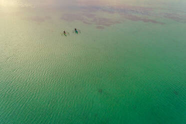 Aerial view of two men in traditional outrigger boats, Dauis, Philippines. - AAEF01161