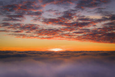 Luftaufnahme von oberhalb der Wolken/Nebel mit Blick auf den Sonnenuntergang. - AAEF01348