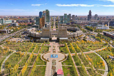 Aerial view of Nur Sultan Entertainment Centre, Kazakhstan. Taken during the day in Autumn. The Lovers park looks beautiful in the foreground. With the Bayterek tower in the distance. - AAEF01358