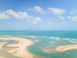 Aerial view of people practicing kitesurfing near a natural sand bank, Cascavel, Brazil. - AAEF01406