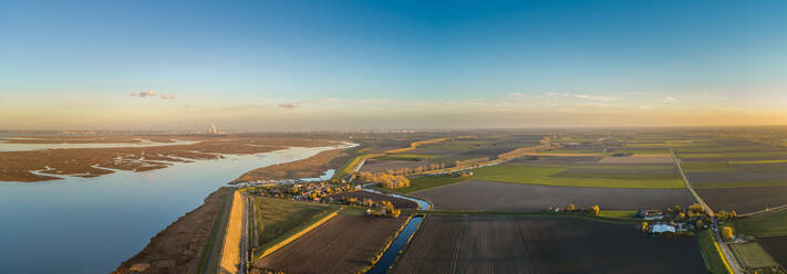 Panoramaluftaufnahme eines kleinen Dorfes, das von einem Hochwasserschutzwall umgeben ist, Niederlande. - AAEF01422