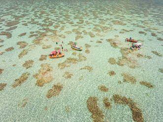 Aerial view of people swimming and eating on Jangadas, traditional small fishing boats in Rio do Fogo, Brazil. - AAEF01470