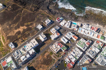 Aerial view above of a coastal village in Canary island archipelago with traditional white houses, Tinajo, Spain. - AAEF01509