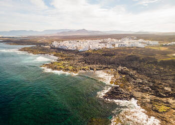 Aerial view of a coastal village in Canary island archipelago with traditional white houses, Tinajo, Spain. - AAEF01512