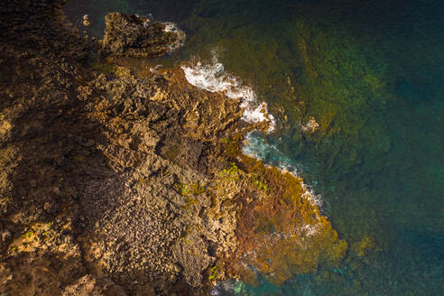 Luftaufnahme von sich brechenden Wellen an einer Küste mit Felsformation, Spanien. - AAEF01518