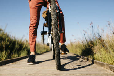 Nahaufnahme des Vorderrads eines Fahrrads auf einem Holzsteg - JRFF03574