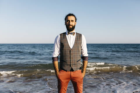 Porträt eines gut gekleideten Mannes am Strand am Wasser, lizenzfreies Stockfoto