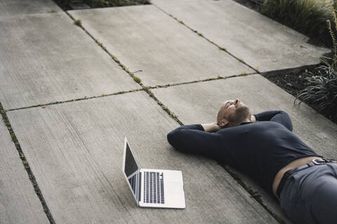 Mann mit Laptop macht eine Pause, lizenzfreies Stockfoto