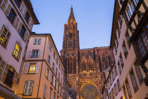 Niedriger Blickwinkel auf Gebäude und Notre Dame de Strasbourg gegen klaren Himmel bei Sonnenuntergang, Frankreich, lizenzfreies Stockfoto