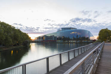 Louise Weiss Gebäude am Fluss gegen den Himmel in der Stadt bei Sonnenuntergang, Strasbourg, Frankreich - JUNF01731