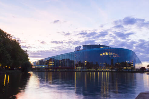 Louise Weiss Gebäude am Fluss gegen den Himmel bei Sonnenuntergang, Straßburg, Frankreich - JUNF01732