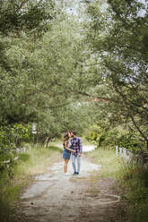 Young couple kissing on a path - LJF00631