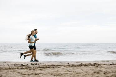 Junges Paar joggt am Strand - JRFF03670