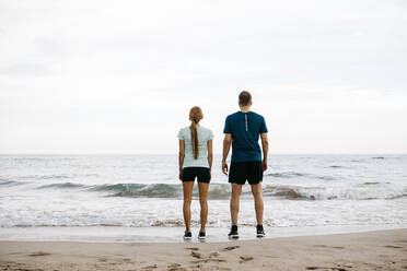 Junges Paar, das Seite an Seite am Strand steht - JRFF03675