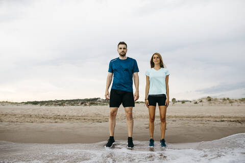 Junge Jogger stehen am Strand, lizenzfreies Stockfoto