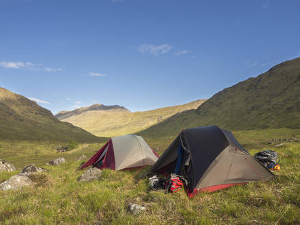 Zelte auf einer Wiese vor blauem Himmel an einem sonnigen Tag, Schottland, UK - HUSF00053